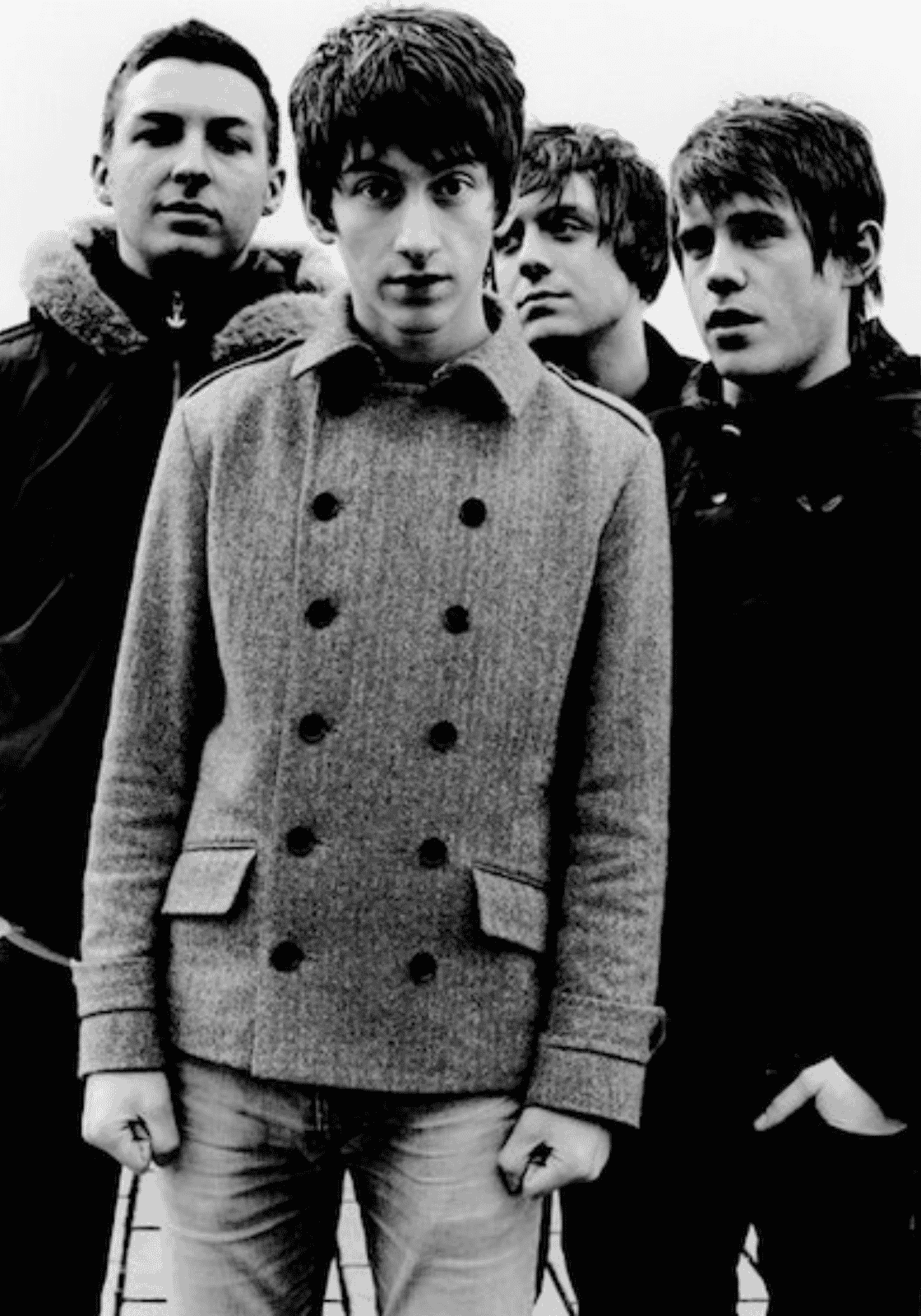 A fiatal Arctic Monkeys tagjai fekete-fehér csoportképen, Alex Turner középen