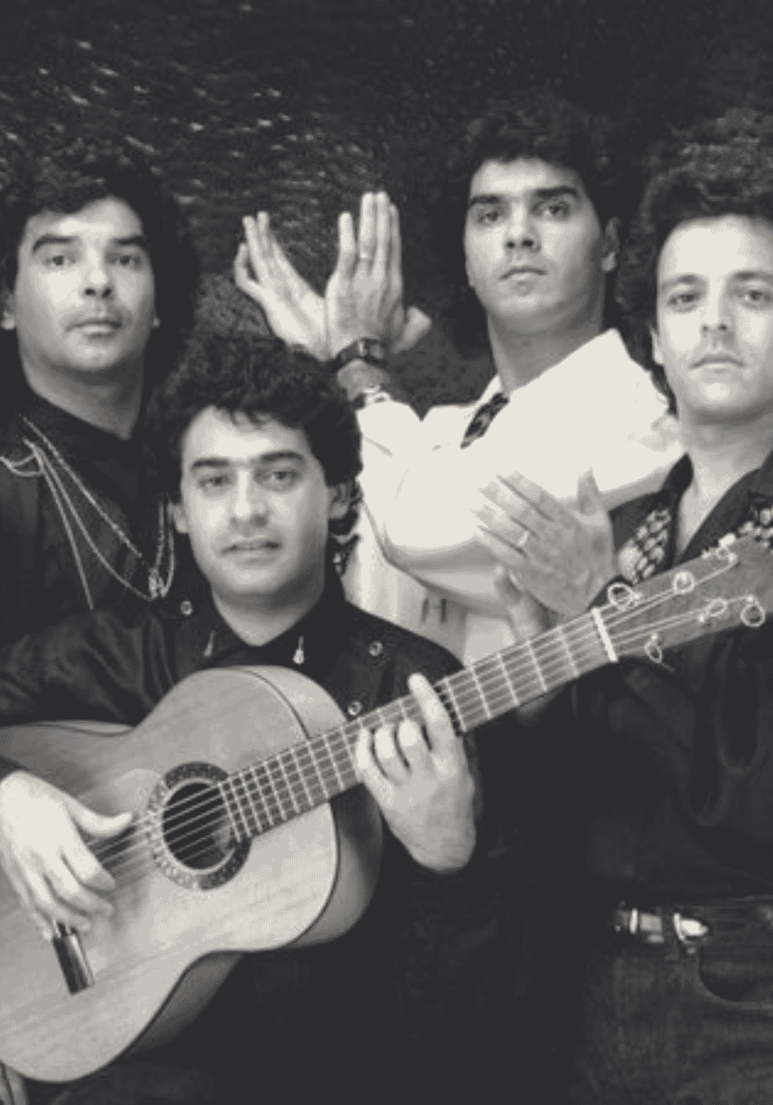 Fiatal Gipsy Kings-tagok fekete-fehér csoportképen, gitárral és tapssal