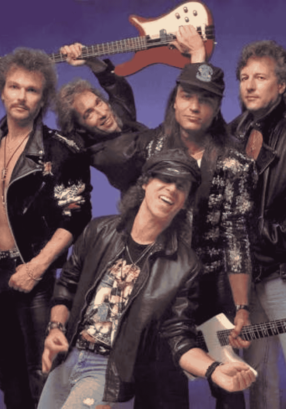 A Scorpions tagjai fekete bőrruhában, egyikük fehér gitárt emel a feje fölé