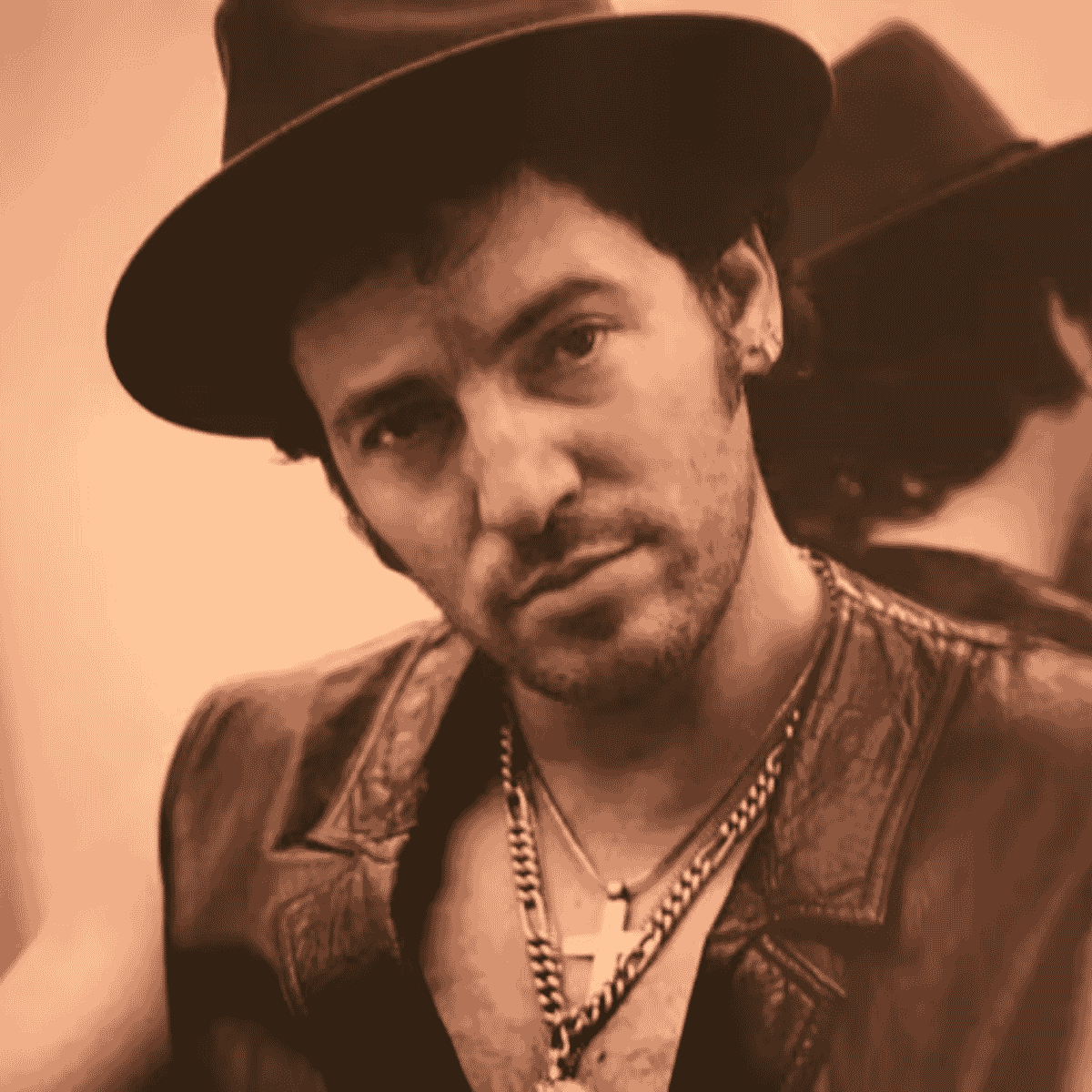 Bruce Springsteen kalapban, meleg színű közeli portrén