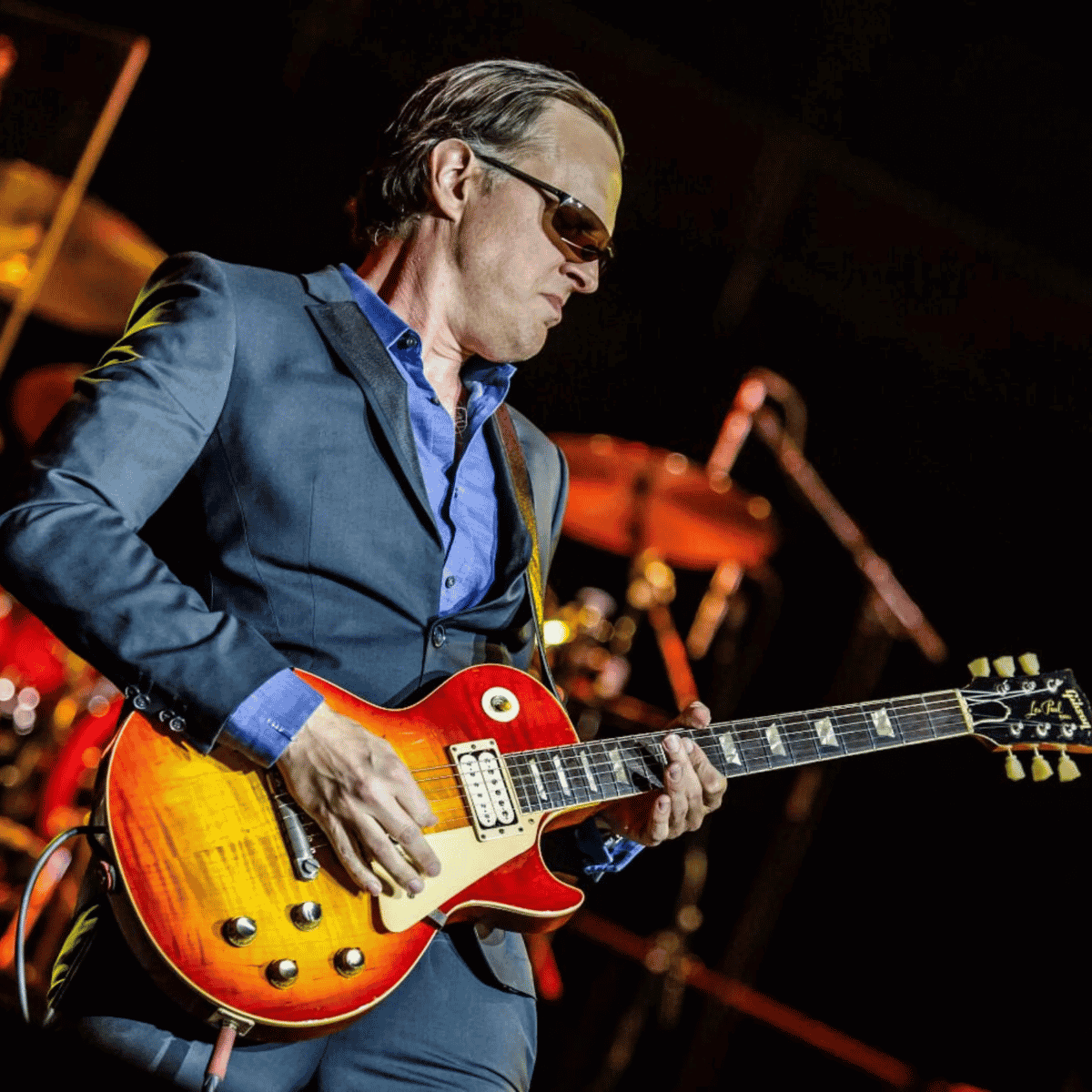 Joe Bonamassa színpadon játszik egy vörös-narancs elektromos gitáron