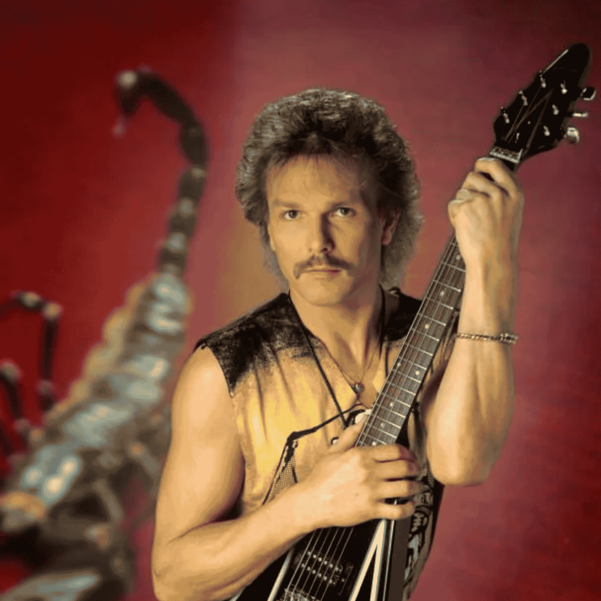 Rudolf Schenker Flying V gitárral vörös színpadi fényben