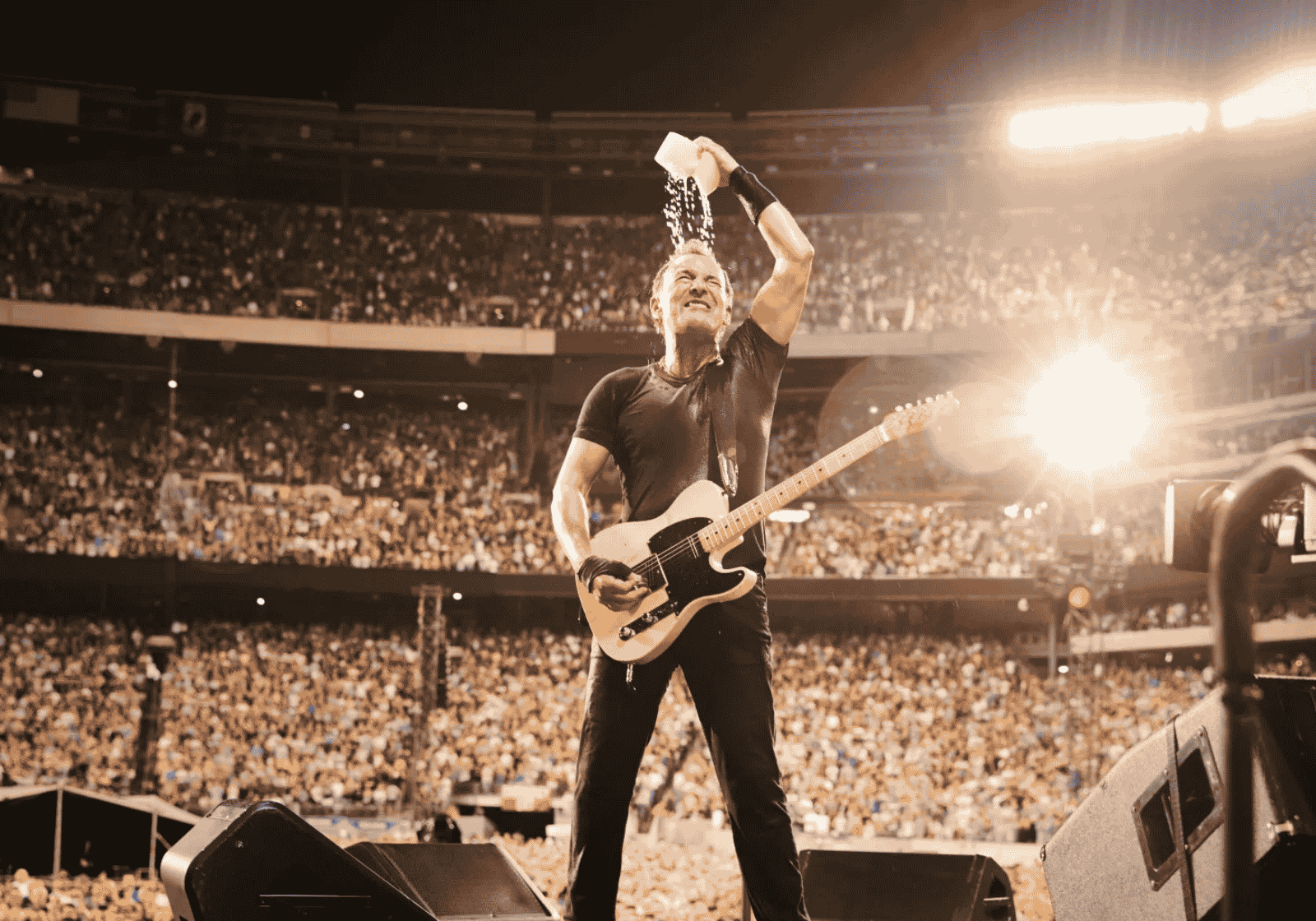 Bruce Springsteen gitárral a stadionban, vizet önt a fejére a közönség előtt